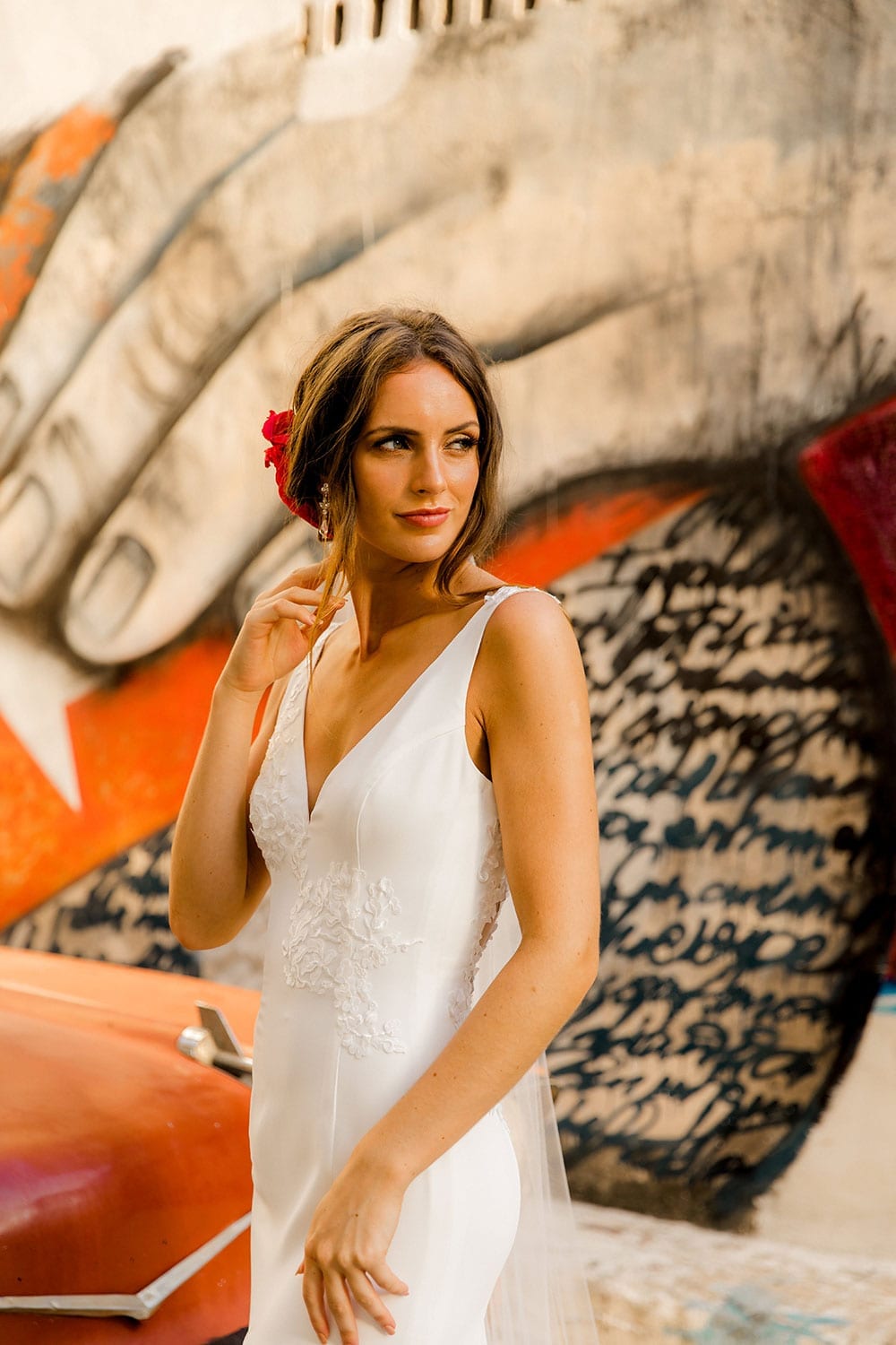 Model wearing Vinka Design Carmen Wedding Dress, a V Neck A-Line Wedding Gown worn on the streets of Havana with colourful walls