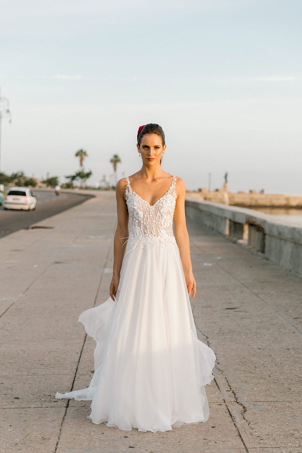 Model wearing Vinka Design Iris Wedding Dress, a Silk Chiffon Wedding Gown posed on a paved walkway in Havana foreward facing