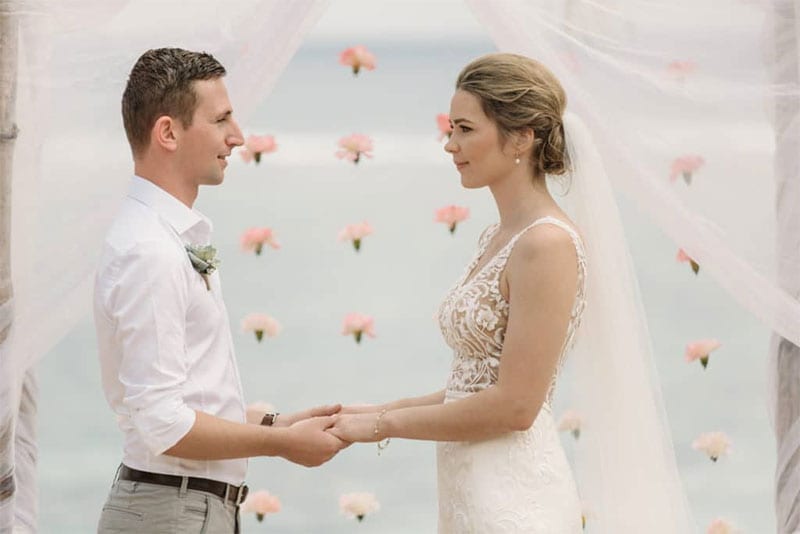 Testimonials | Vinka Design | Real Bridal Reviews from Our Clients | Amy and Kris face to face at wedding ceremony Amy's bespoke designer gown with beautiful lace bodice highlighted