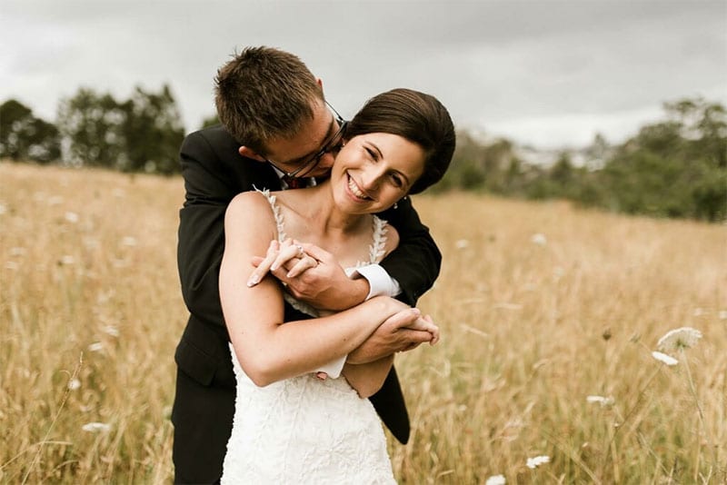 Testimonials | Vinka Design | Real Bridal Reviews from Our Clients | Jessica and Michael embracing in field