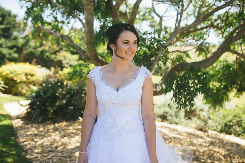 Testimonials | Vinka Design | Real Bridal Reviews from Our Clients | Kat under trees in sunlight in bespoke wedding dress