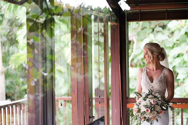 Testimonials | Vinka Design | Real Bridal Reviews from Our Clients | Marisa looking out of window with front bodice lace detail of bespoke gown shining