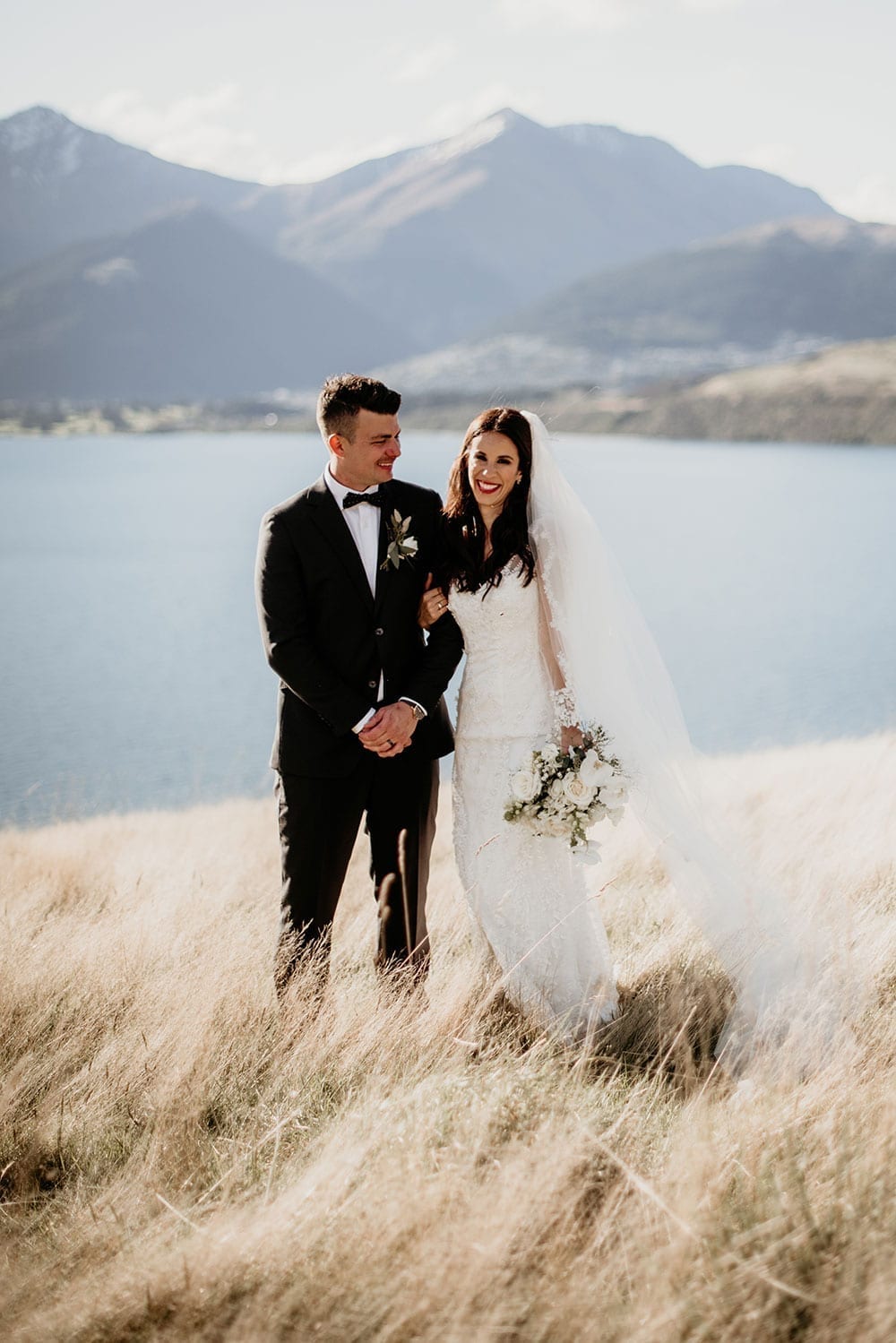 Vinka Design Features Real Weddings - Bride in custom made gown with groom in front of remarkables mountains