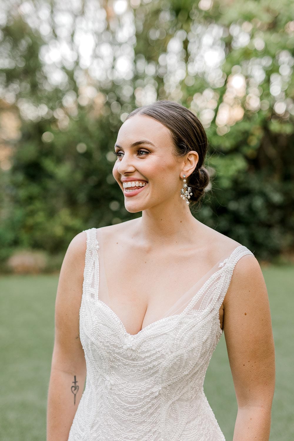 Juliette Wedding Dress from Vinka Design. Flattering stretch fitted lace wedding dress with beautiful ivory rich beading. Structured bodice provides support while remaining effortless to wear. Close up of structured bodice with neckline. Photographed at Tui Hills.