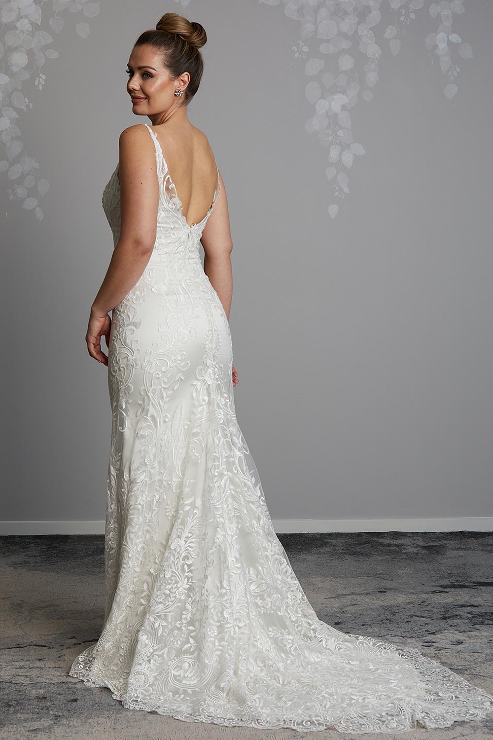Sahara Wedding Dress from Vinka Design. Stunning fitted lace wedding gown. Lightly-beaded floral lace highlights the ivory stretch satin base. Sweetheart neckline & low back with beautiful lace detail. Full length view of the low scoop back of the dress with long lace train.