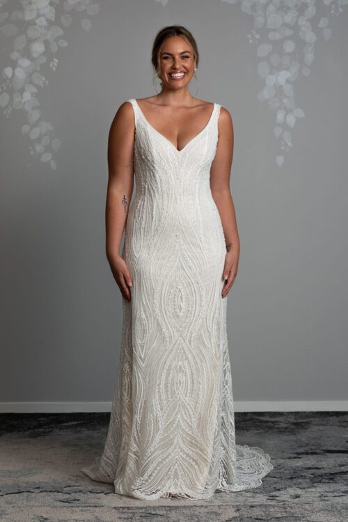 Kiera Wedding Dress from Vinka Design. Beautifully beaded lace wedding dress. Deep V-neckline both front and back is complemented with delicate sheer lace shoulder detail & structured bodice. Full length view of gown with deep V-neckline and delicate beaded lace and long train