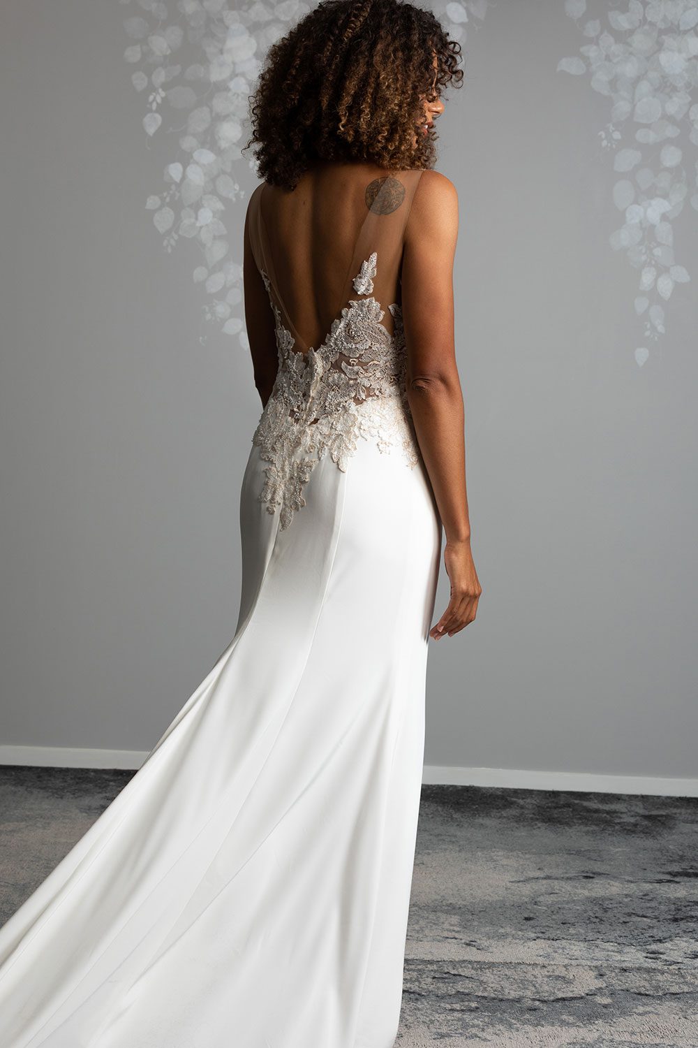 Samantha Wedding Dress from Vinka Design. This beautiful wedding dress has a nude sheer illusion strapless neckline made from fine Italian tulle. Low sheer back & structured bodice, & soft crepe train. Back view of model showing low sheer back and bridal crepe train