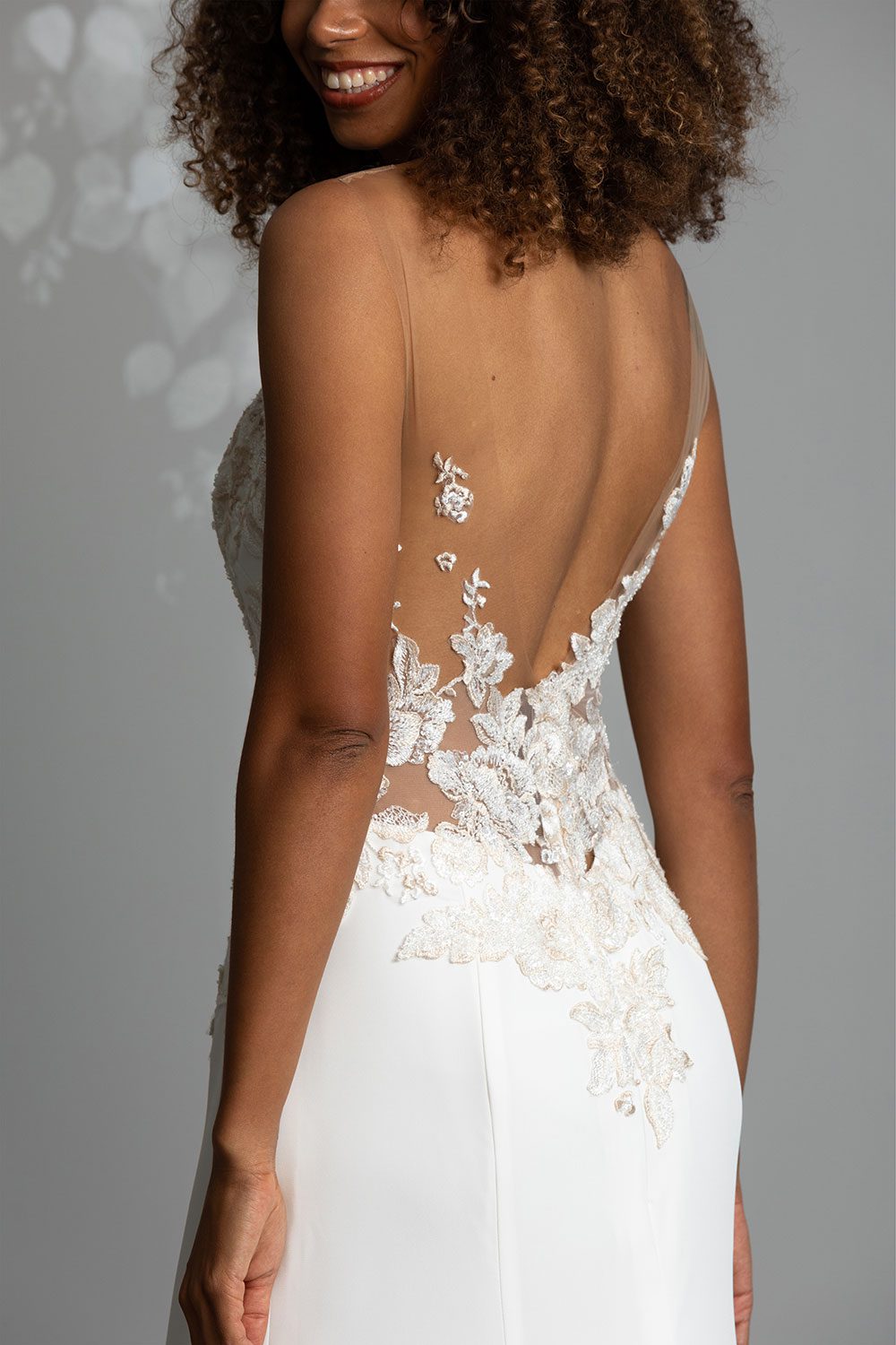 Samantha Wedding Dress from Vinka Design. This beautiful wedding dress has a nude sheer illusion strapless neckline made from fine Italian tulle. Low sheer back & structured bodice, & soft crepe train. Model showing full length back view of dress with low sheer illusion back with delicate lace