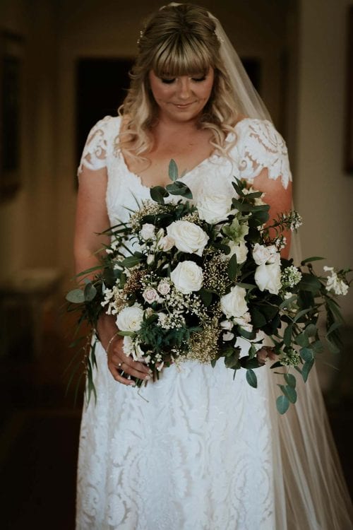Vinka Design Features Real Weddings - bride wearing bespoke Vinka wedding gown - holding large flower bouquet