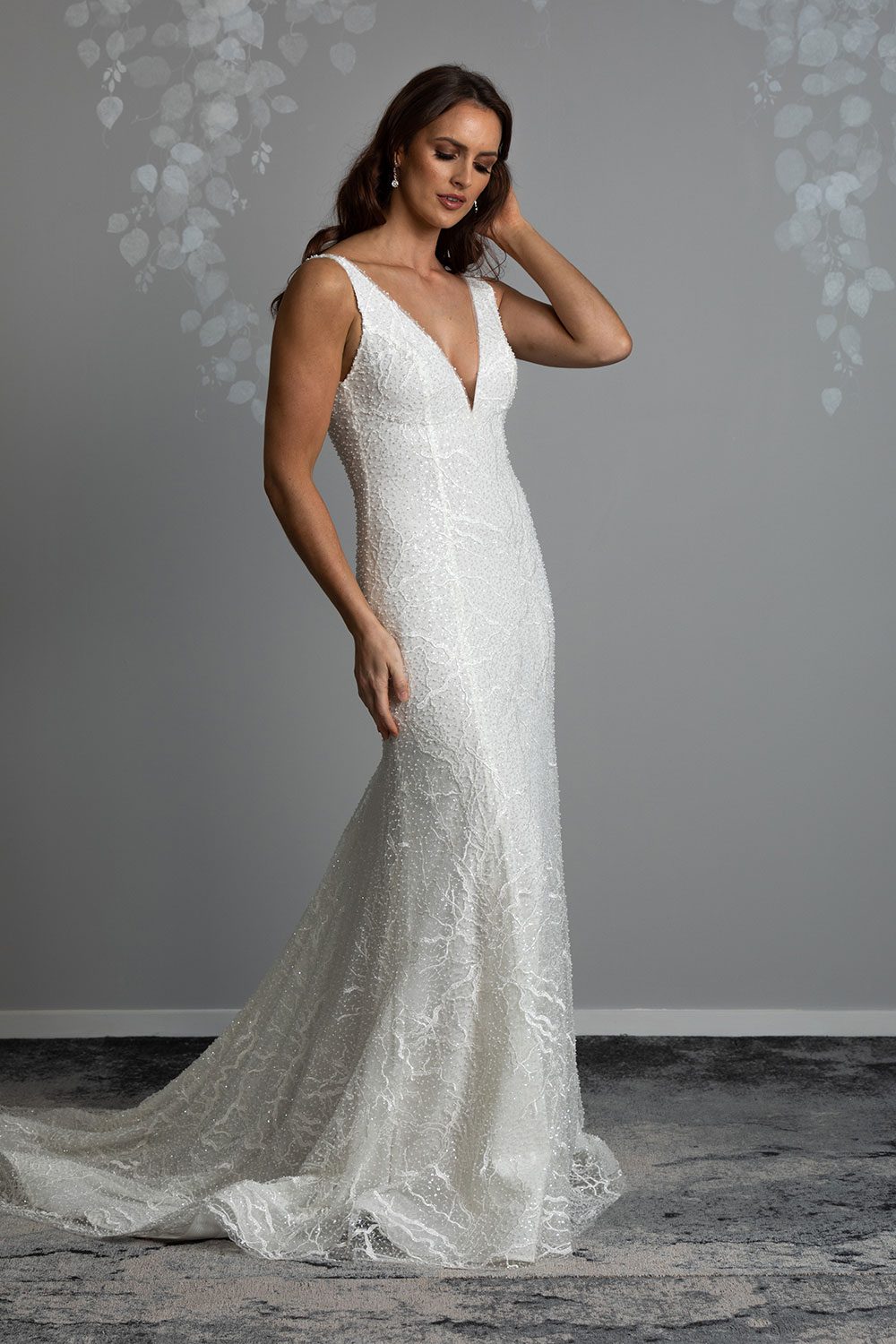 Farrah Wedding gown from Vinka Design - This beautiful wedding dress is constructed with fully beaded embroidered lace on a stretch base. V-neckline with a low, square back cut in a fit-and-flare style, which gently sculpts and enhances curves. Full length view of dress with low V shaped neckline and beaded embroidered lace throughout