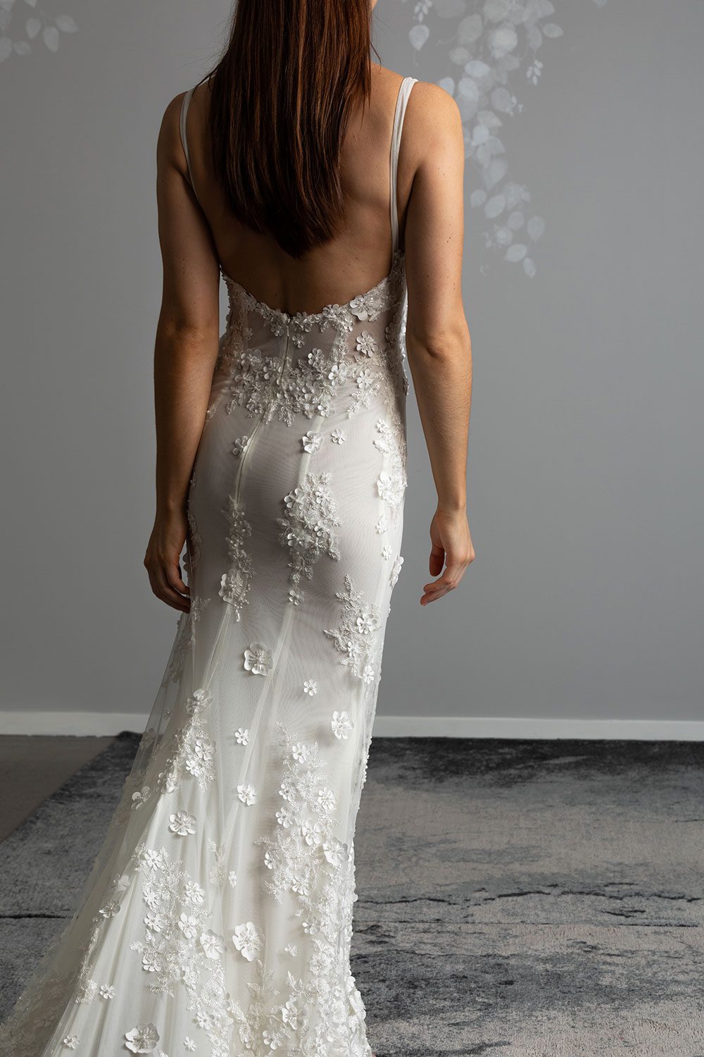 E'more Wedding gown from Vinka Design - This stunning lace wedding gown is hand sewn with a fully beaded 3D flower embroidery. Structured and boned bodice with scoop neckline in the front and low back. Stretch fit skirt flares into full lace train. Back view of low back and semi sheer base with 3D floral embroidery