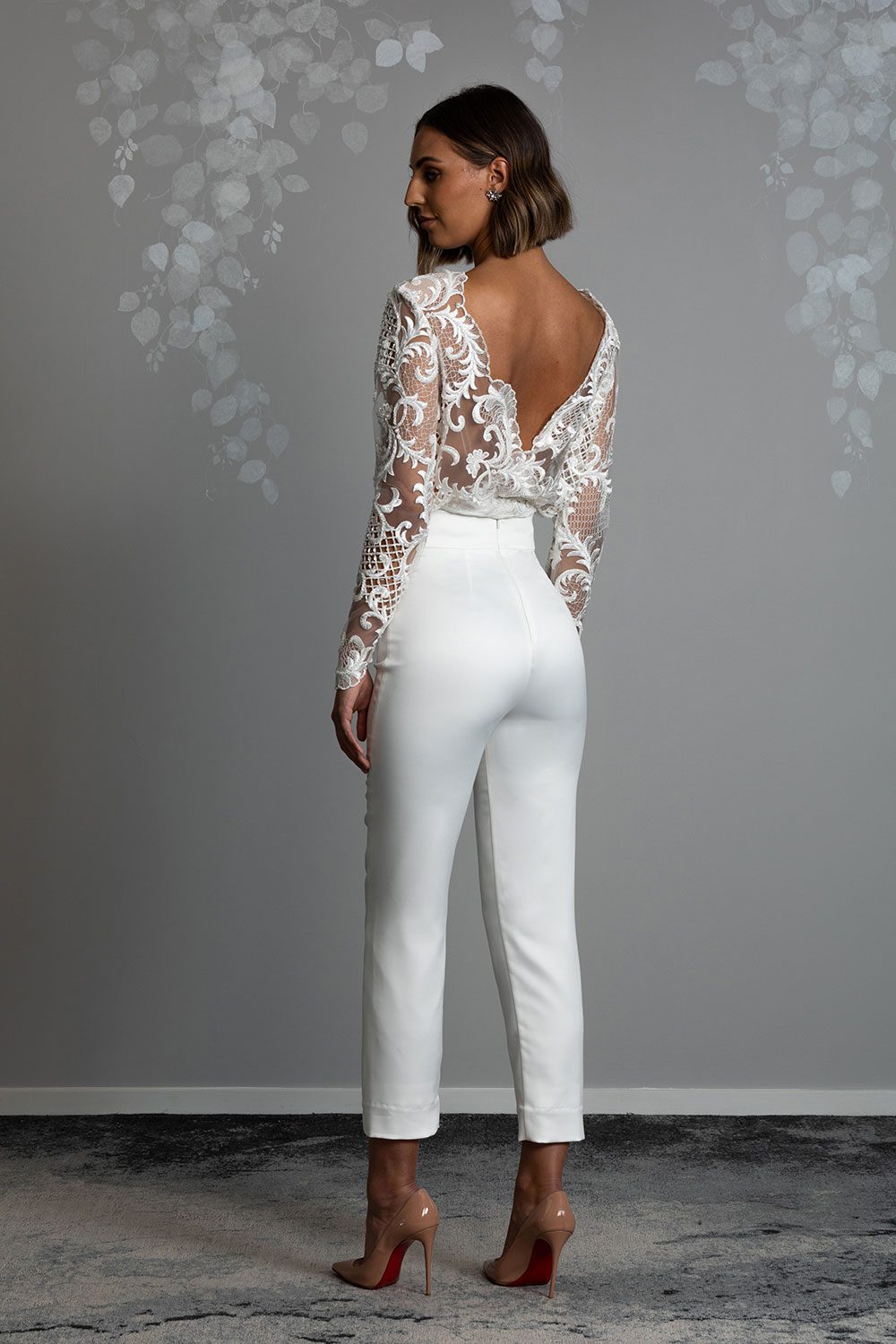 Ava Wedding Trousers and Blouse from Vinka Design - Elegantly tailored trouser combined with a beautiful lace blouse for the Modern Bride. The blouse features a high neck and low back, with in-built camisole, fitted sleeves, & pearl buttons. Full back view showing scalloped lace blouse with v cut back and perfectly fitted trousers