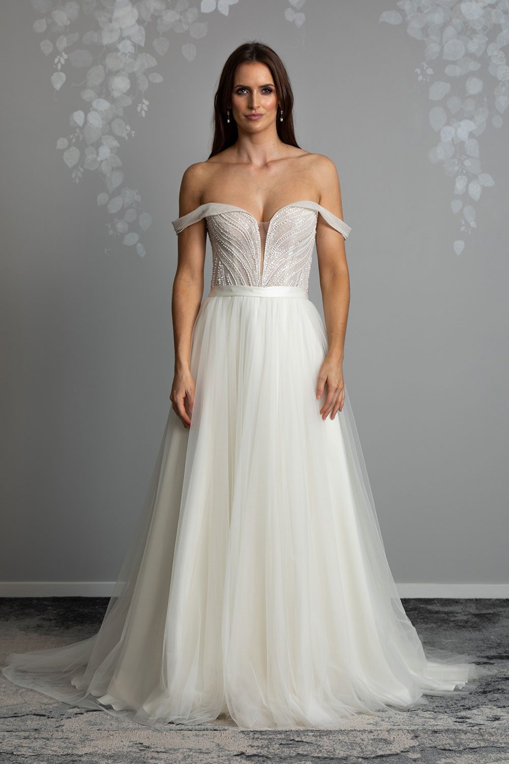 Aroha Wedding gown from Vinka Design - Beautiful & intricate pearl beading is hand-appliqued along this wedding gown’s structured, boned bodice. Delicate off-shoulder straps are complemented by the sweetheart neckline. - front view of model showcasing the fitted bodice against the soft tulle skirt