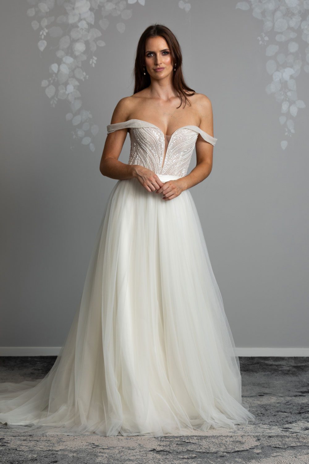 Aroha Wedding gown from Vinka Design - Beautiful & intricate pearl beading is hand-appliqued along this wedding gown’s structured, boned bodice. Delicate off-shoulder straps are complemented by the sweetheart neckline. - front view of model with beaded bodice and soft tulle skirt