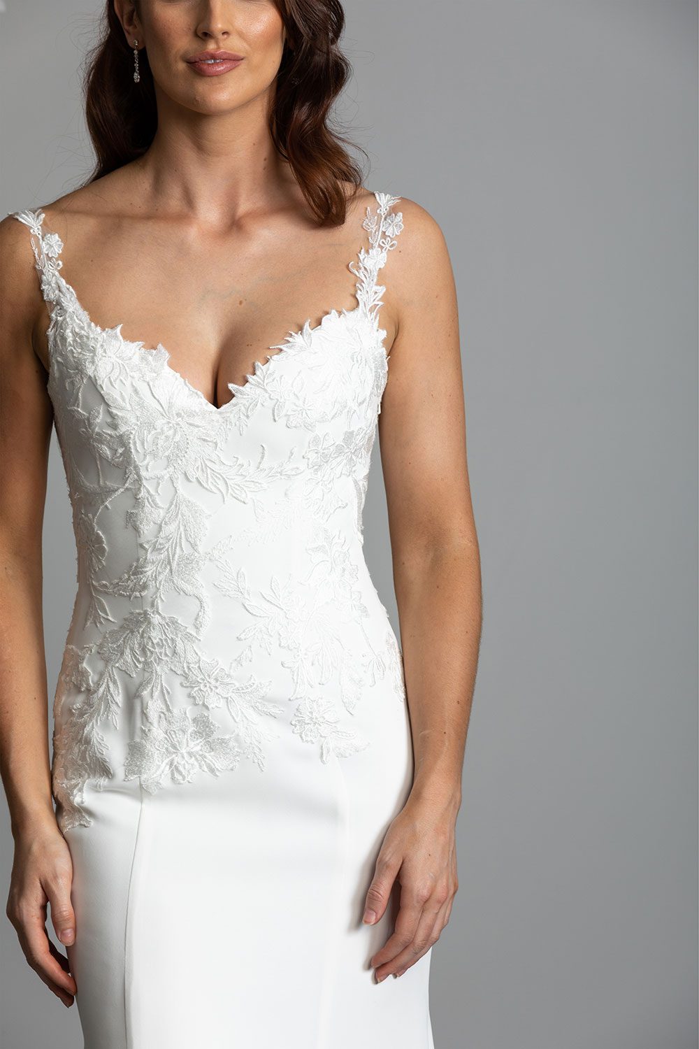 Ana Wedding gown from Vinka Design - This beautiful gown is graced by hand-appliqued delicate floral leaf lace, subtly worked into the front of the bodice and more prominently on the back. A fit-and-flare cut shapes the figure. Close up of front of the gown and intricate lace detail