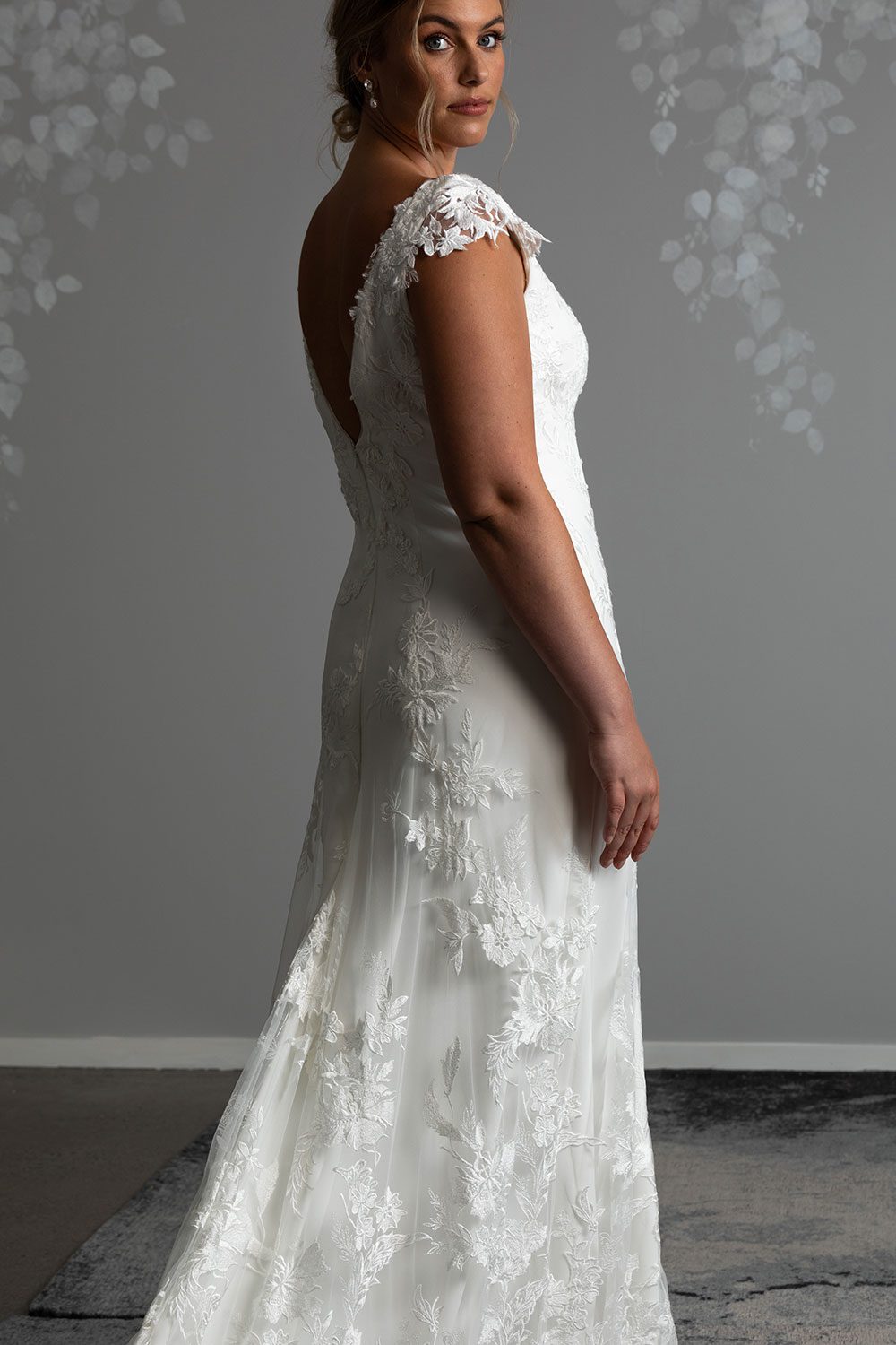 Beautiful A-line wedding gown in stretch satin and botanical lace. Featuring a V-neckline & bodice with intricately hand-appliquéd floral embellishments. Low Back. Vinka Design