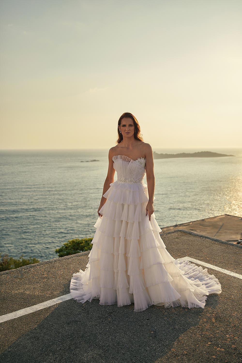 Experience Antonia, a bridal gown with drama & detail. Features 3D lace, a semi-sheer bodice, and layers of pleated silk draping on a ball gown silhouette. Vinka Design