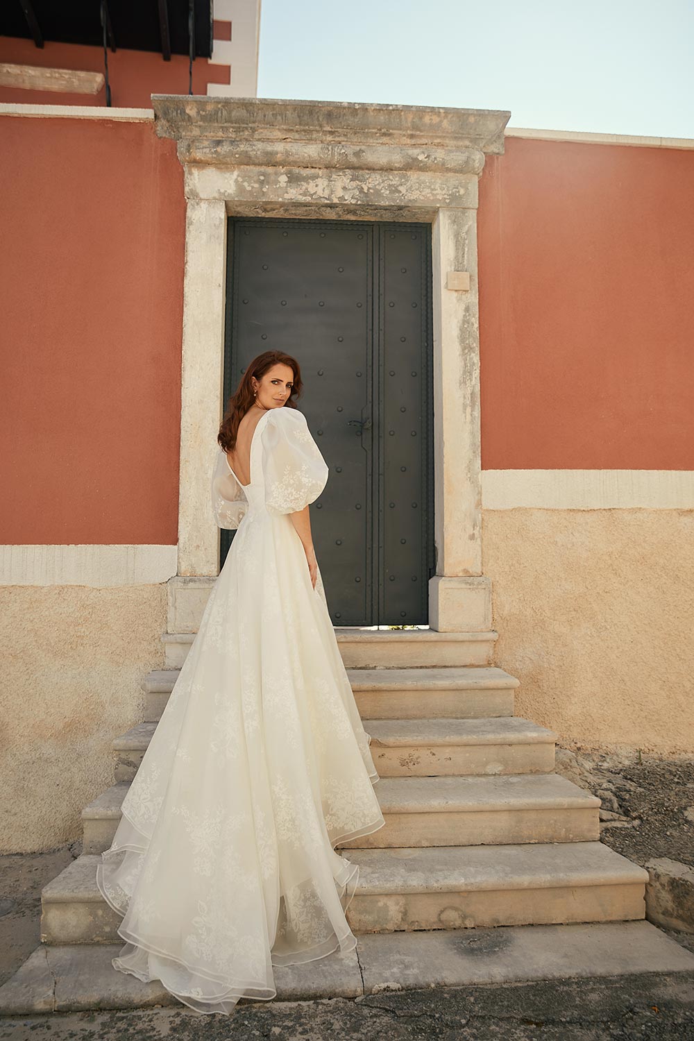 Discover Wedding Gown Bianca's blend of boldness and fragility. Features a plunging V-neckline, basque waist, sweeping silk organza train & detachable sleeves. Vinka Design