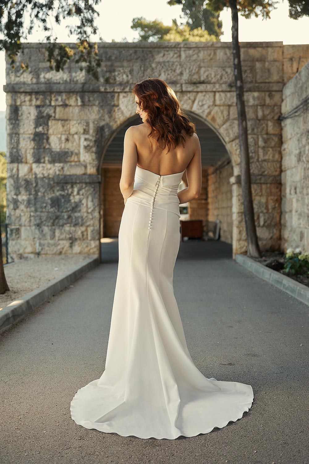 Mara, a minimalist bridal gown with stunning silhouette. Strapless wedding dress in heavyweight Japanese stretch polyester with a seductive split and train. Vinka Design