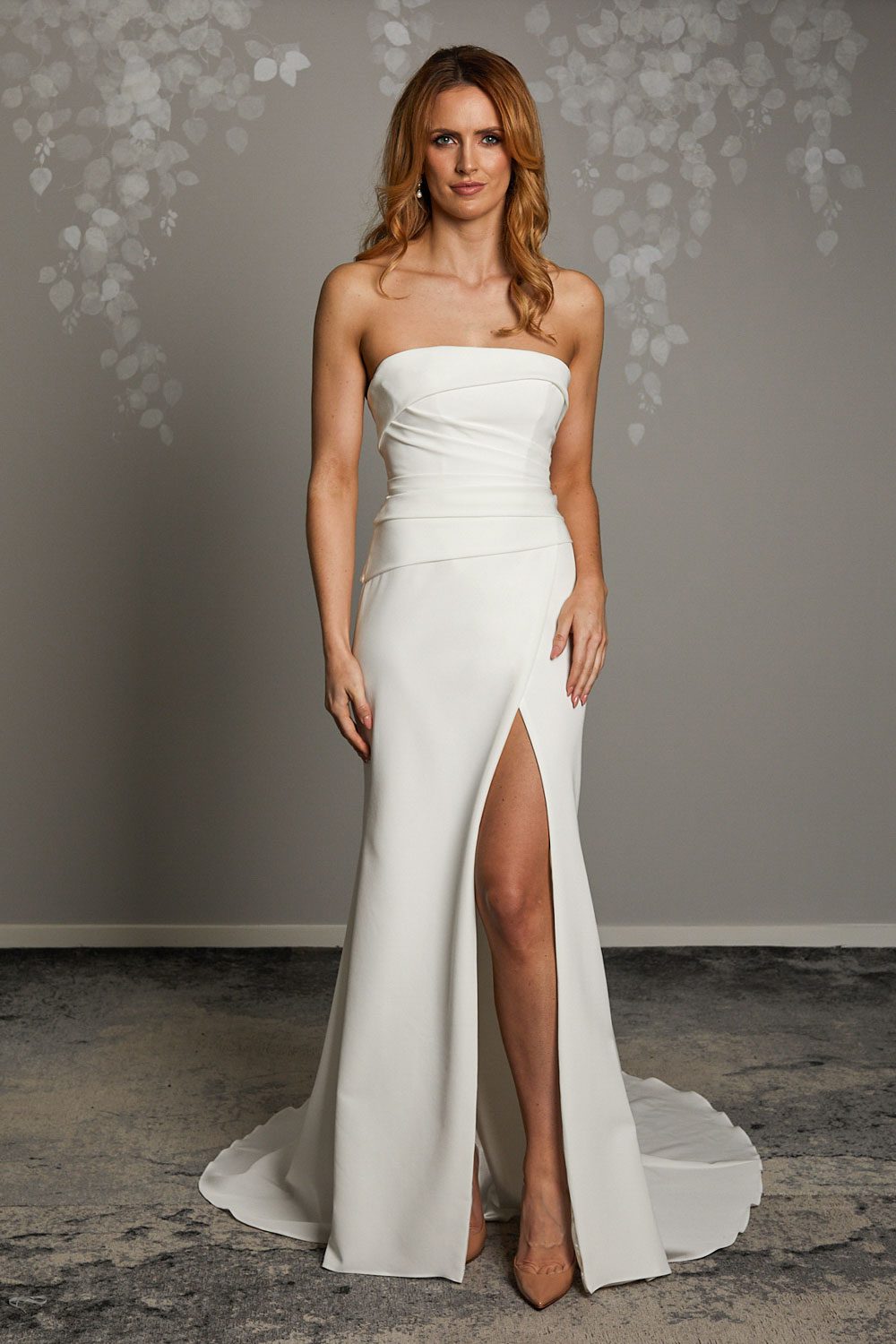 Mara, a minimalist bridal gown with stunning silhouette. Strapless wedding dress in heavyweight Japanese stretch polyester with a seductive split. From Vinka Design, Auckland, New Zealand